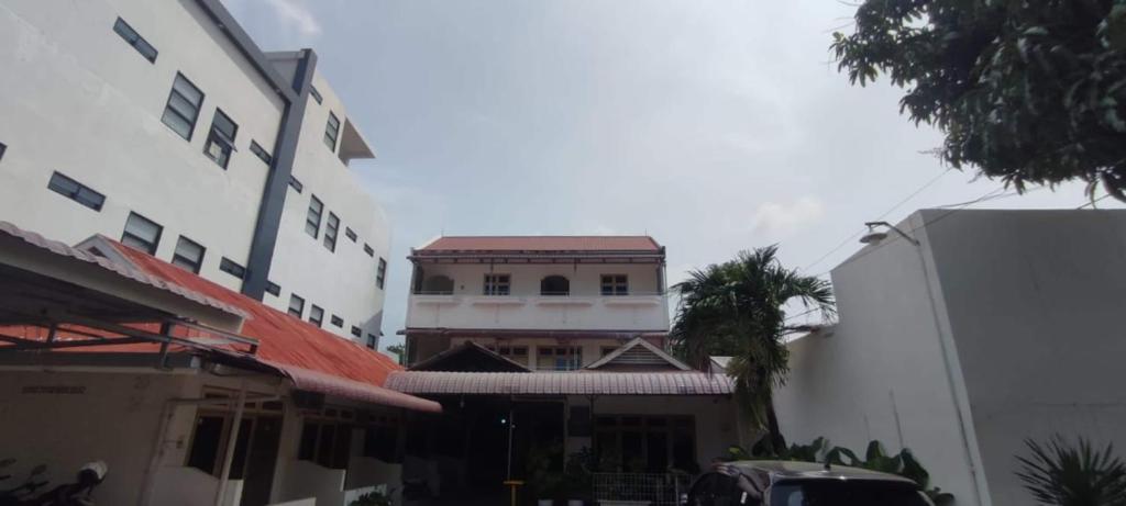 ein Gebäude in der Mitte einiger Gebäude in der Unterkunft Capital O 93467 Wisma Olo Syariah in Padang