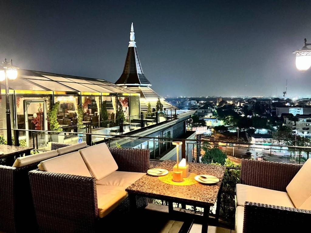 Sky dome resotel في بانكوك: بلكونه فيها طاوله وكراسي ومبنى