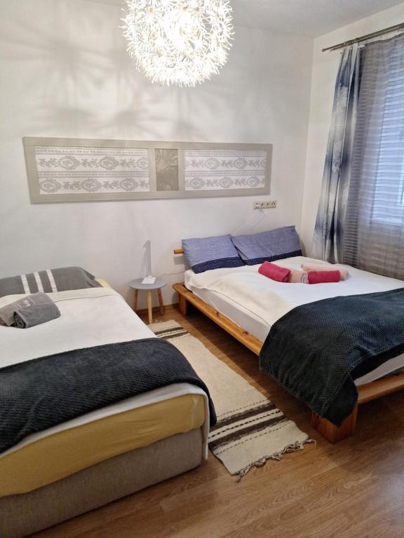 two beds in a bedroom with a chandelier at Ferienwohnung in Erlauf