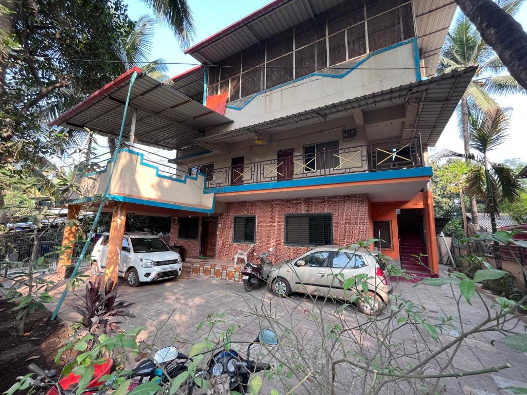 dom z dwoma samochodami zaparkowanymi przed nim w obiekcie Patil Homestay w mieście Alibag