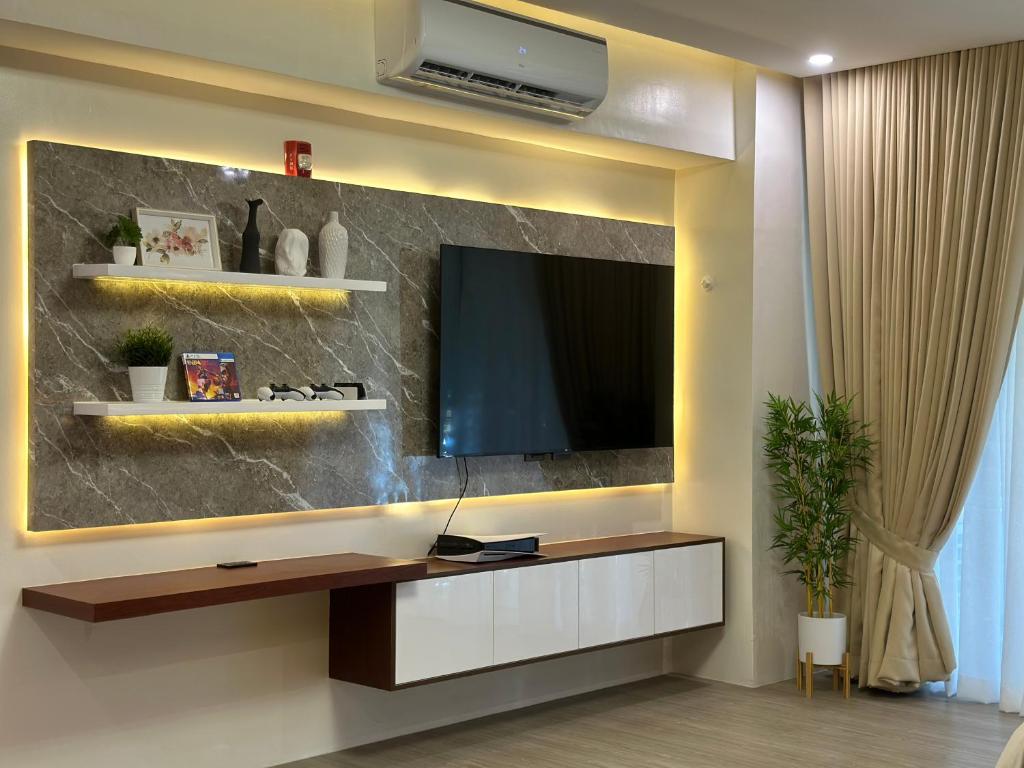 a living room with a tv on a wall at The Beach Suites at Pico De Loro in Nasugbu