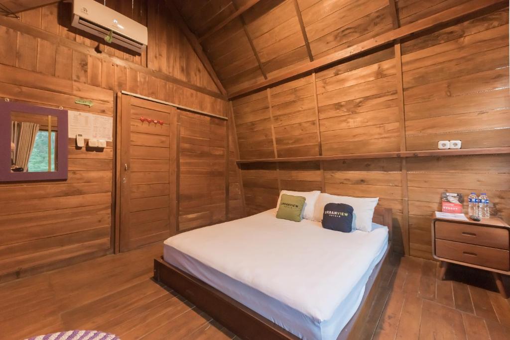 a bedroom with a bed in a wooden room at Urbanview Hotel Cianjur City Park by RedDoorz in Tjiandjur