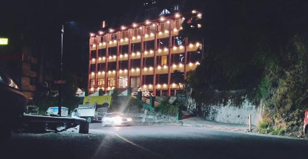 un edificio con luces por la noche en Taarra view green with parking en Gangtok