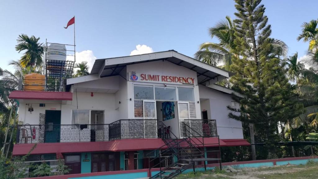 a building with palm trees in front of it at Hotel SRI KPN , Austinabad in Austinābād