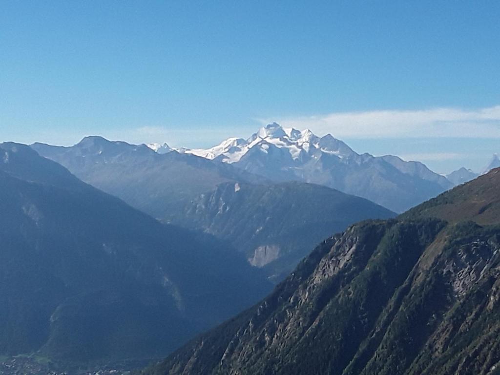 a view of a mountain range with snow capped mountains at DesAlpes in Saxeten