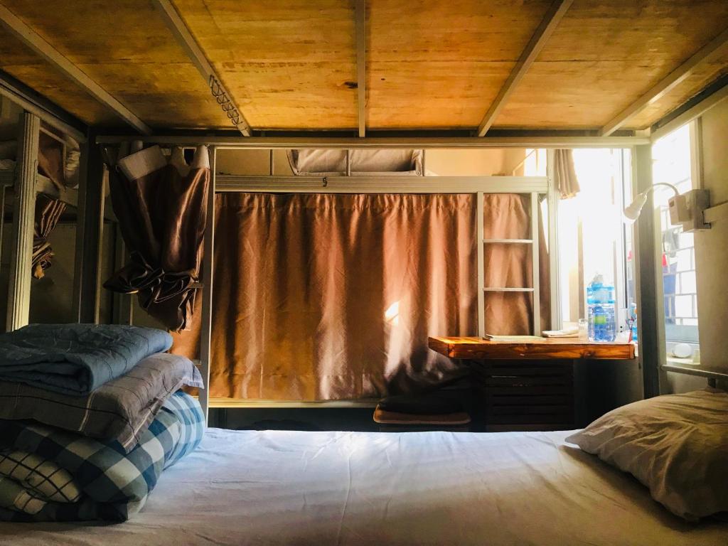 a bedroom with a bed and a desk and a window at Annie Backpacker Hostel in Ban Nongdouang