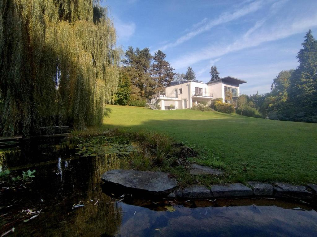 een huis op een heuvel met een vijver ervoor bij Nina´s Home in Gablitz