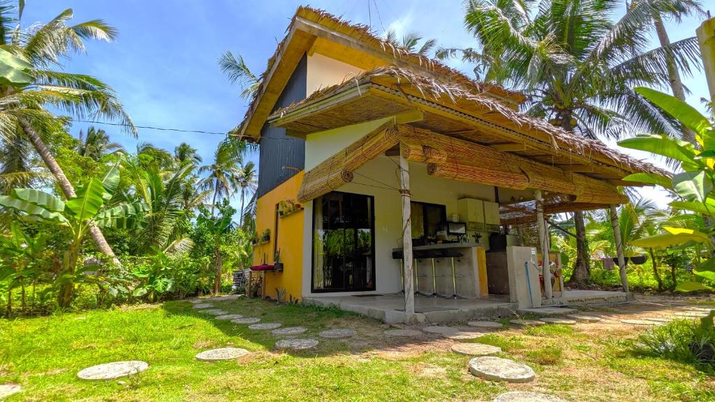 a yellow house with a kitchen in front of it at Tropical Haven with Dedicated Office Space in Siargao in General Luna
