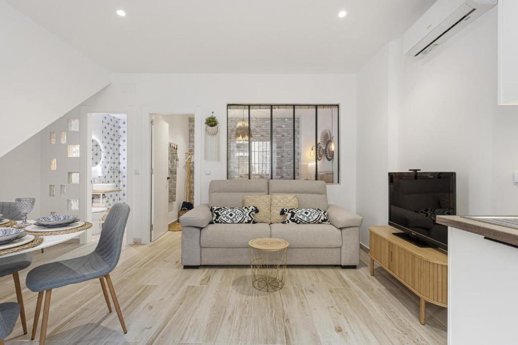 a living room with a couch and a tv at Agua Viva Mar in Málaga