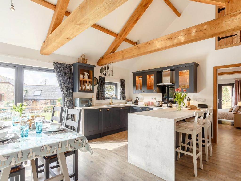 a kitchen with wooden ceilings and a table with chairs at 2 Bed in Bude 66127 in North Tamerton