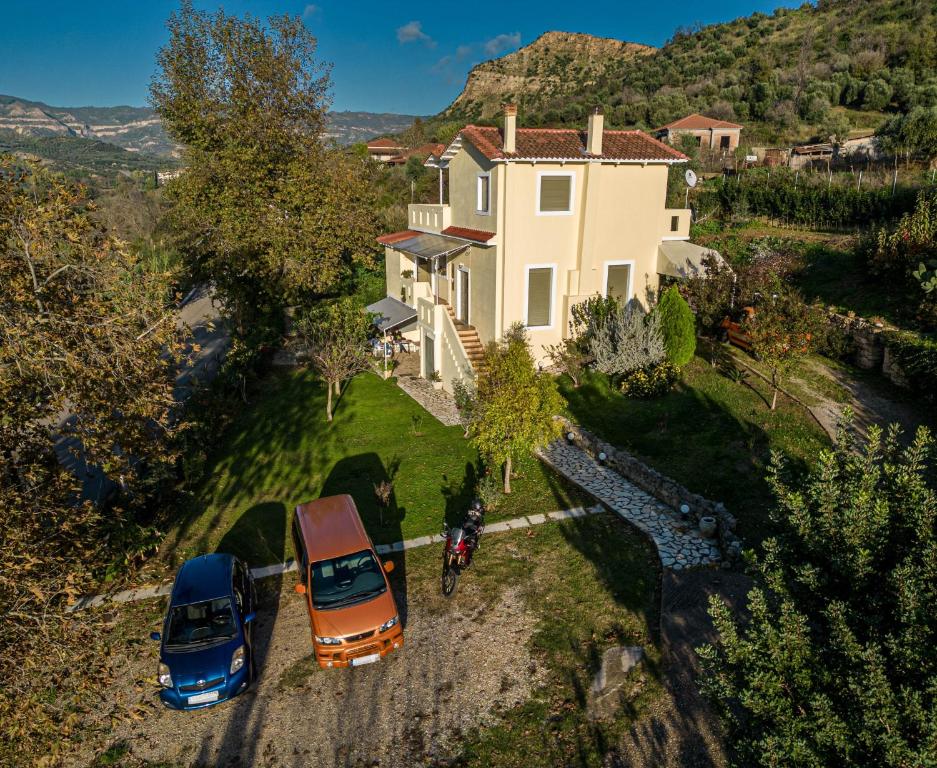 due auto parcheggiate di fronte a una casa di Estia guest house a Olympia