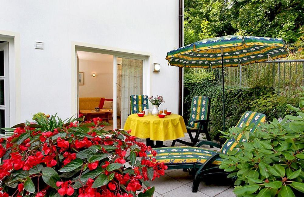 eine Terrasse mit einem Tisch, Stühlen und einem Sonnenschirm in der Unterkunft Usedom Ahoi App 4 in Heringsdorf