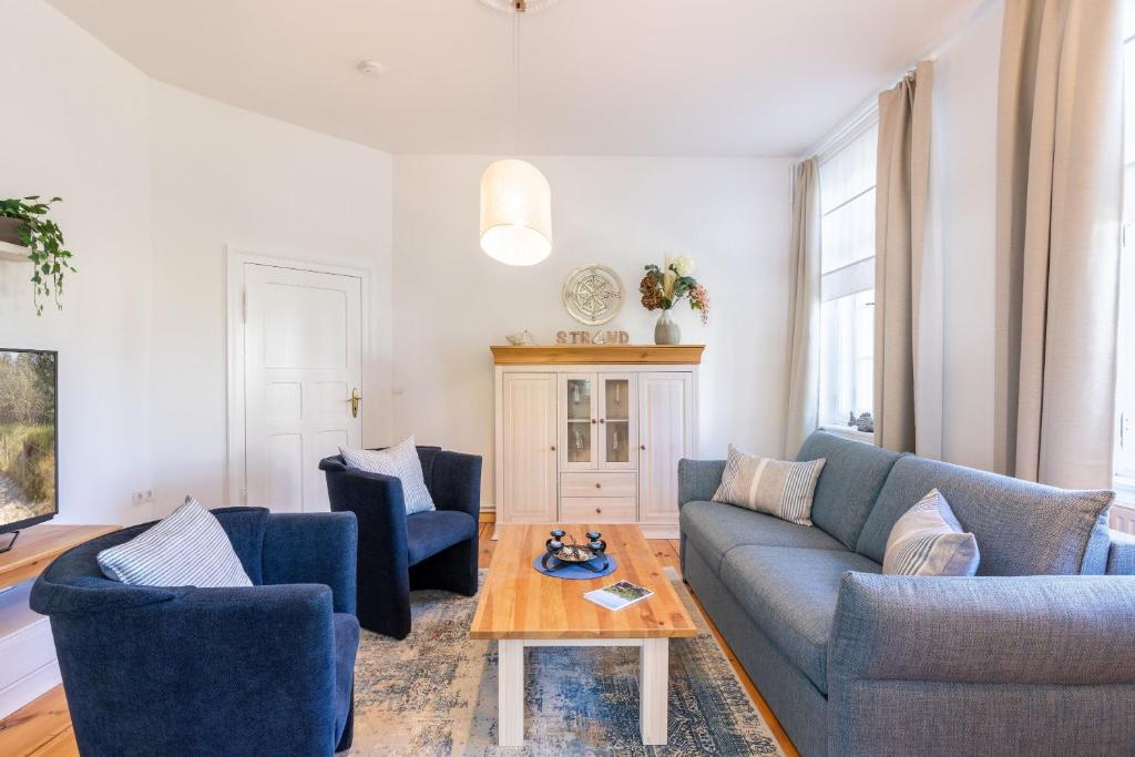 ein Wohnzimmer mit 2 blauen Sofas und einem Tisch in der Unterkunft Villa Albus App 2 in Ahlbeck