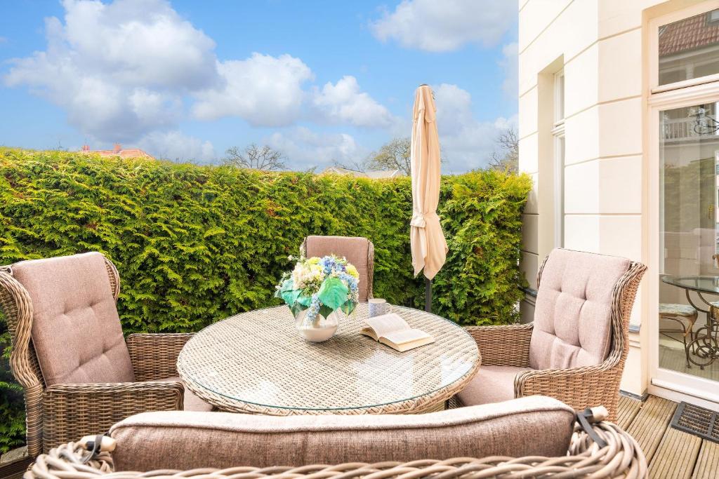 patio con tavolo, sedie e ombrellone di Villa Gruner App 1a a Zinnowitz