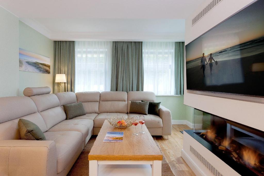 uma sala de estar com um sofá e uma televisão grande em Villa Waldschloss App 2 em Bansin