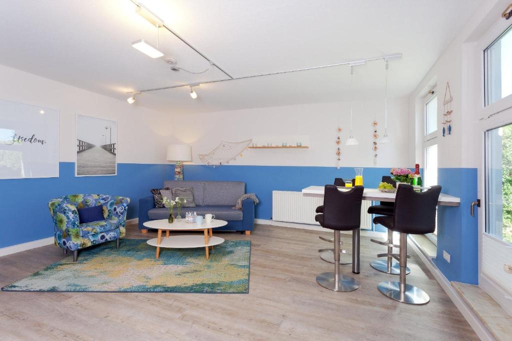 uma sala de estar com paredes azuis e uma mesa e cadeiras em Zum Weißen Rössl App Strandmuschel em Ahlbeck