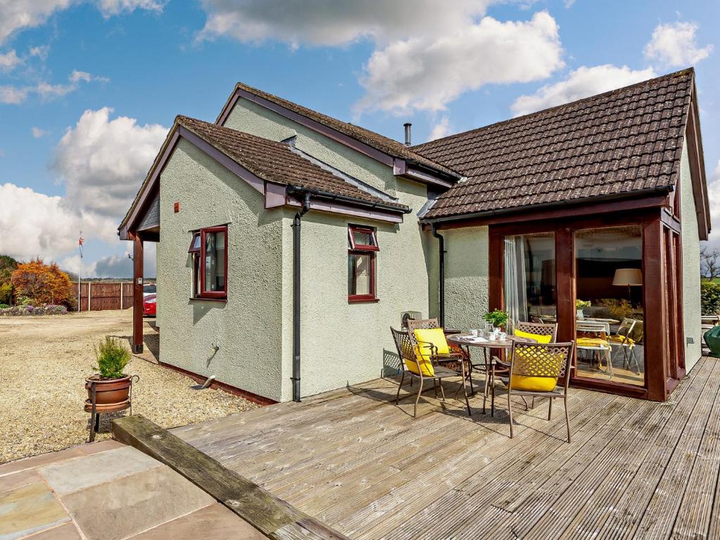 a house with a deck with a table and chairs at 1 Bed in St Briavels 73584 in Saint Briavels