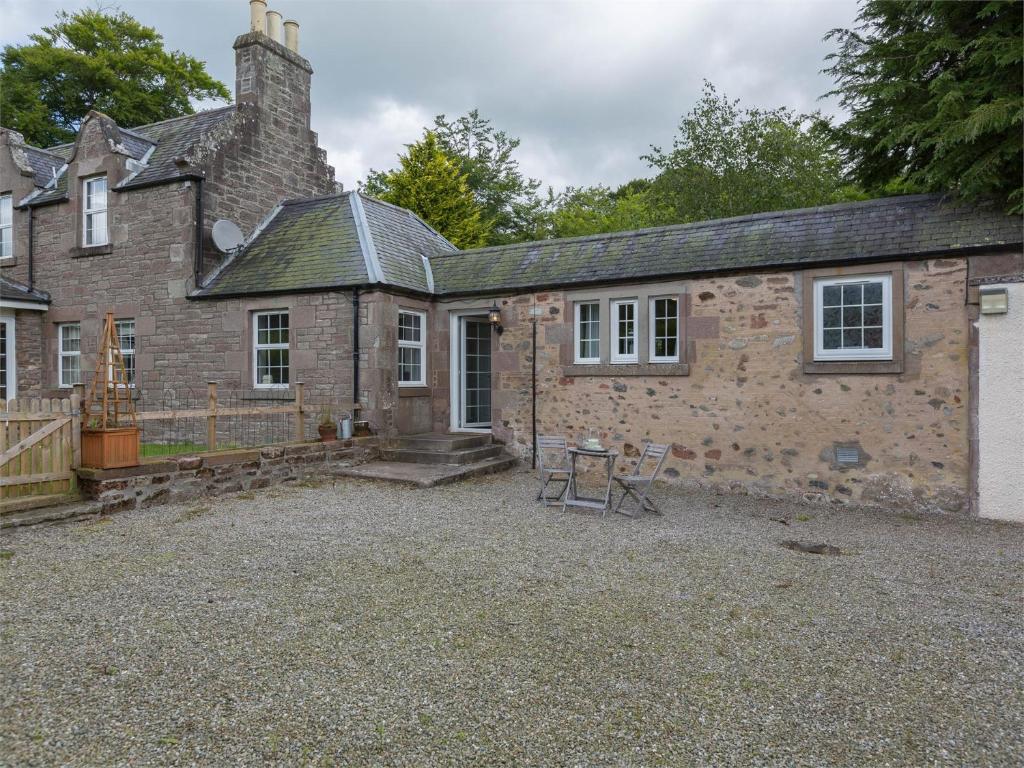 an old stone house with a table in front of it at 1 Bed in Edzell CA217 in Edzell