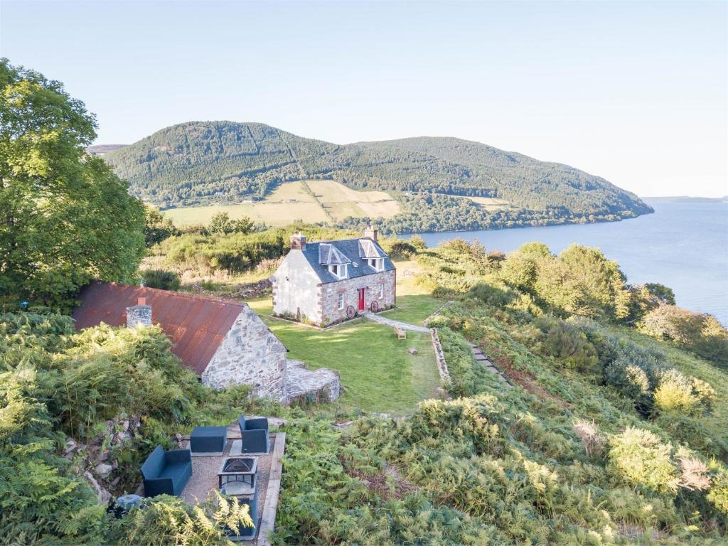 an aerial view of a house on a hill next to the water at 2 bed in Loch Ness CA315 in Drumnadrochit