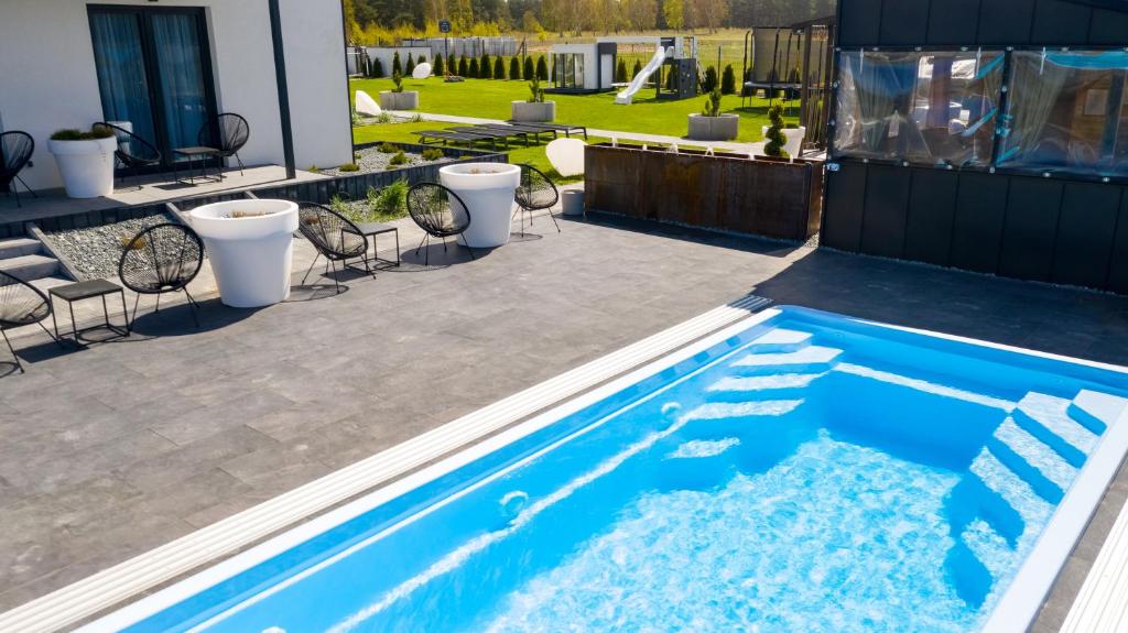 una piscina en medio de un patio en Loox Ostrovo- Boutique House-noclegi nad morzem, en Ostrowo