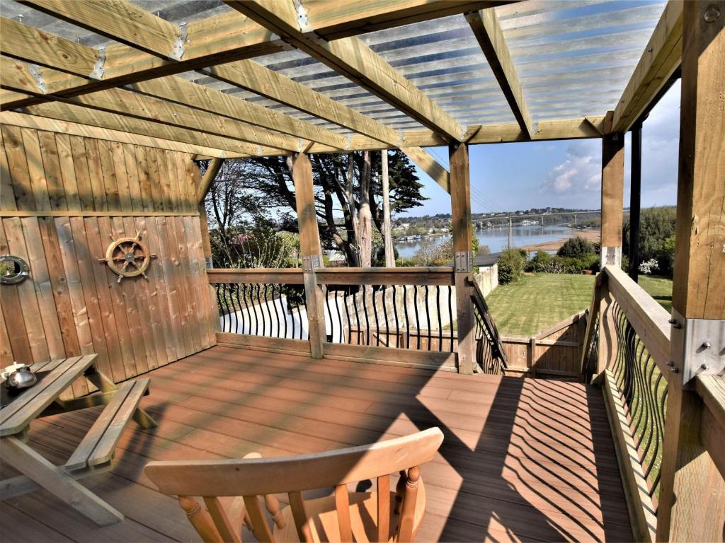 a wooden pergola with chairs and a table on a deck at 1 Bed in Bideford 74817 in Bideford