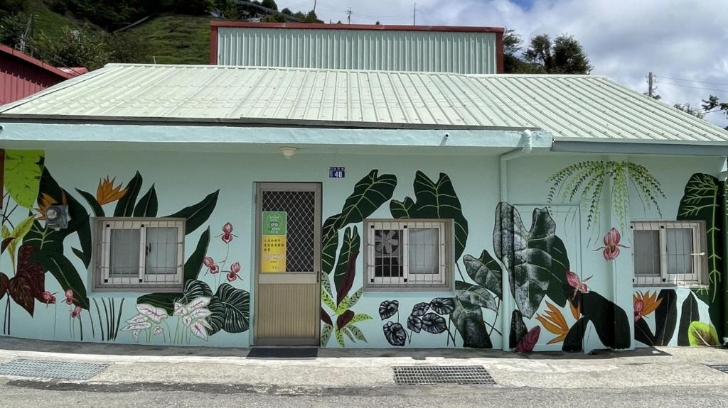 a building with a mural of flowers and plants at 31 Backpack Guest House in Ren'ai