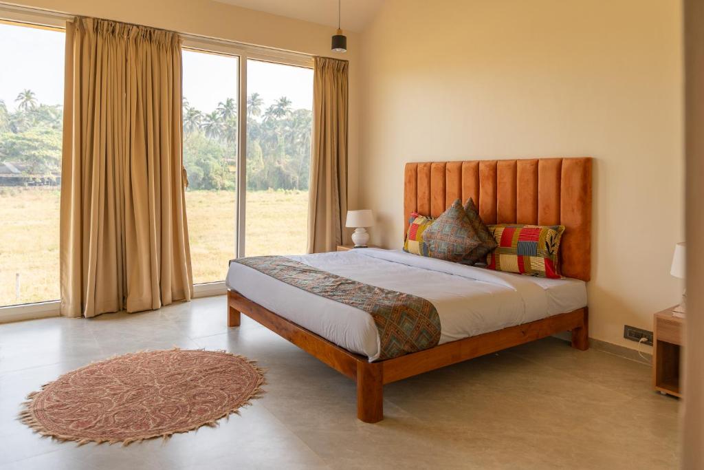 ein Schlafzimmer mit einem Bett und einem großen Fenster in der Unterkunft La Luxo in Anjuna
