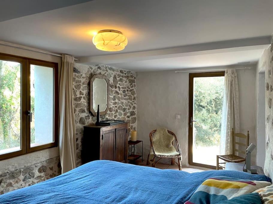 une chambre avec un lit bleu et un miroir dans l'établissement Cozy Catalan Cottage, à Reynès