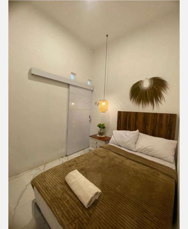 ein Schlafzimmer mit einem großen Bett und einem großen Fenster in der Unterkunft Emerald Guest House type kansas Purwokerto in Banyumas