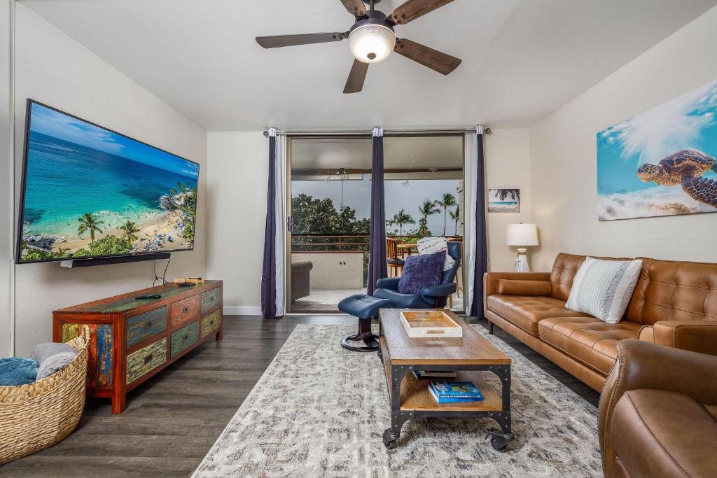 a living room with a couch and a tv at White Sands Village#231 in Kailua-Kona