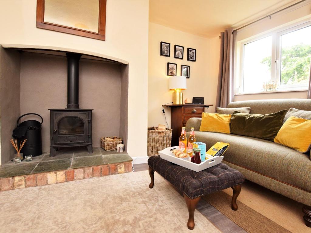 un soggiorno con divano e camino di 2 bed property in Exeter 79431 a Sandford