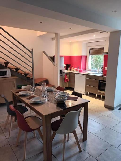 une cuisine avec une table et des chaises dans une pièce dans l'établissement Le coteau 3 chambres, à Charmes