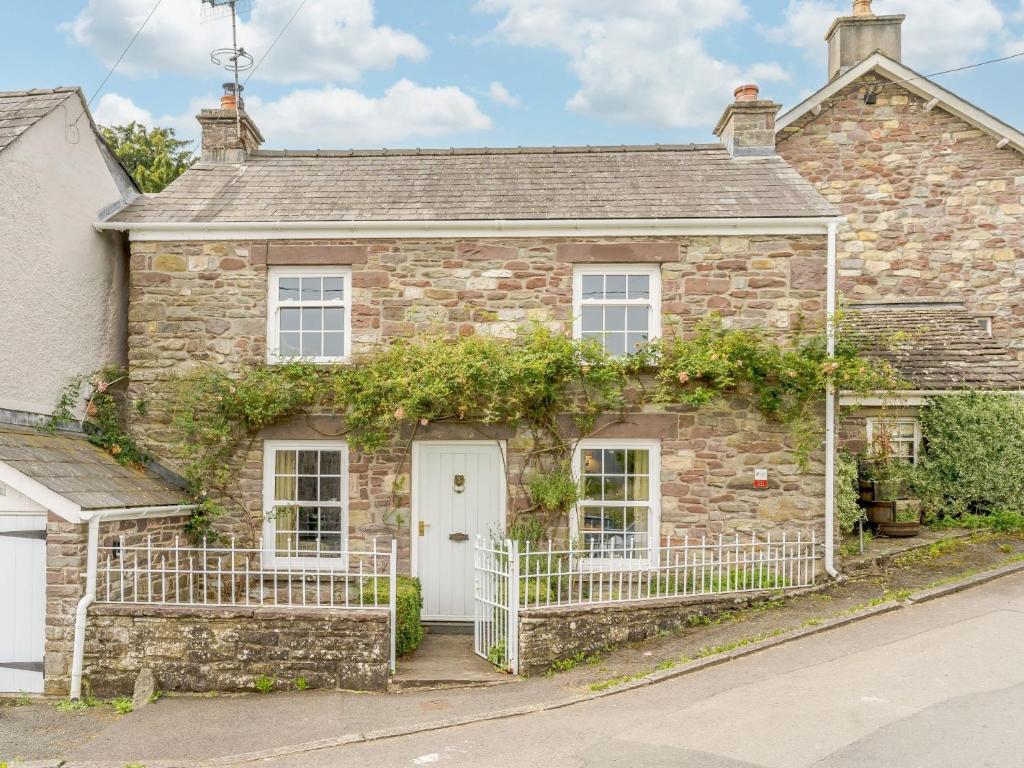 an old stone house with a white fence at 2 bed in Llangynidr BN023 in Llangynidr