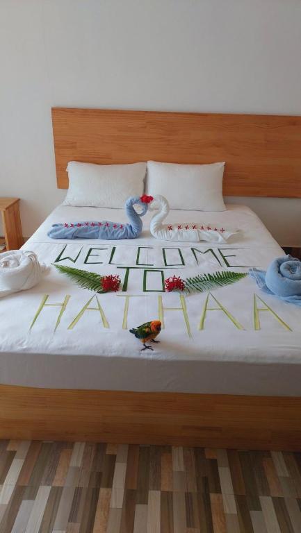 Una cama con flores y pájaros encima. en Fulidhoo Hathaa Retreat, en Fulidhoo