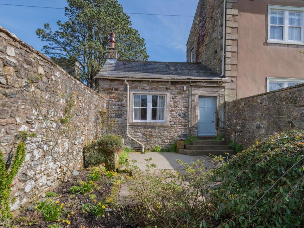 a stone house with a blue door and a stone wall at 2 Bed in Caldbeck SZ212 in Caldbeck