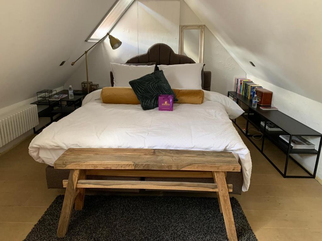 a bedroom with a large white bed with a wooden platform at Guestsuite Sir Joachim Bruges in Bruges