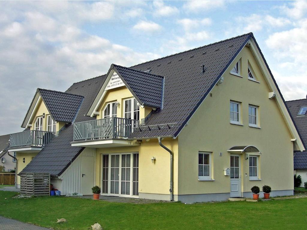 a large yellow house with a black roof at Haus Granitzhof in Binz