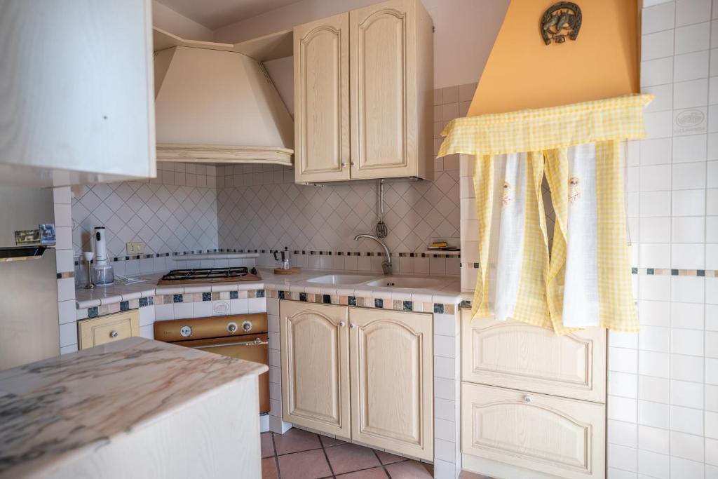 een keuken met witte kasten en een spoelbak bij La Mery Giò House - Fasano in Fasano