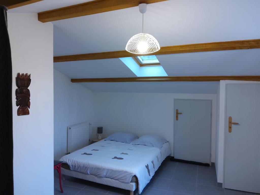 - une chambre blanche avec un lit et une lumière dans l'établissement CABY, à Préguillac