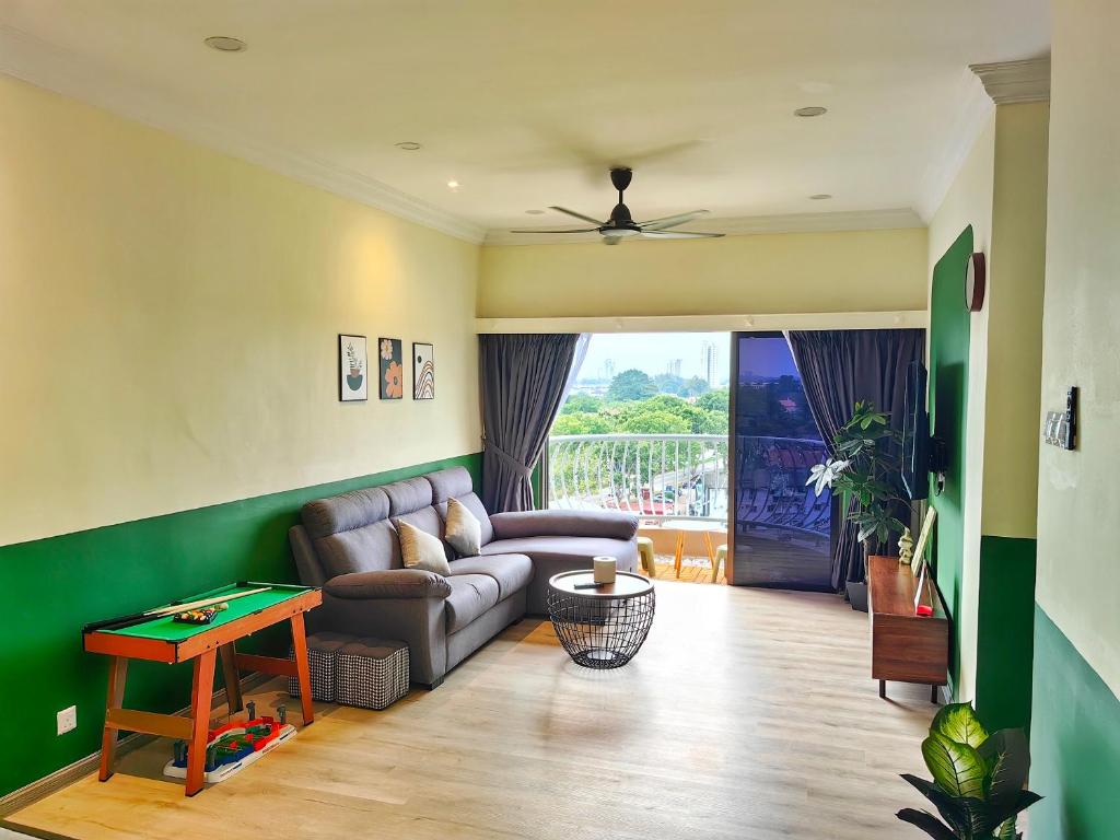 a living room with a couch and a table at Klebang GX Homestay Resort Pool View P0804 with Netflix, TVBox and Games in Malacca