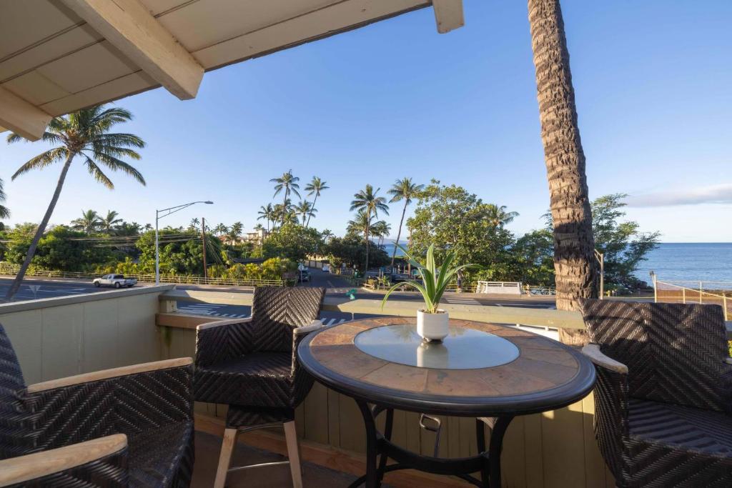 a patio with a table and chairs and the ocean at Shores Of Maui 224 in Kihei