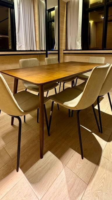 a wooden table and chairs in a room at Damac Jeddah 1408 in Jeddah