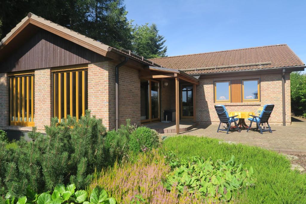 a house with a table and chairs in a garden at Ferienhaus Sonne Harz und Sterne in Hohegeiß