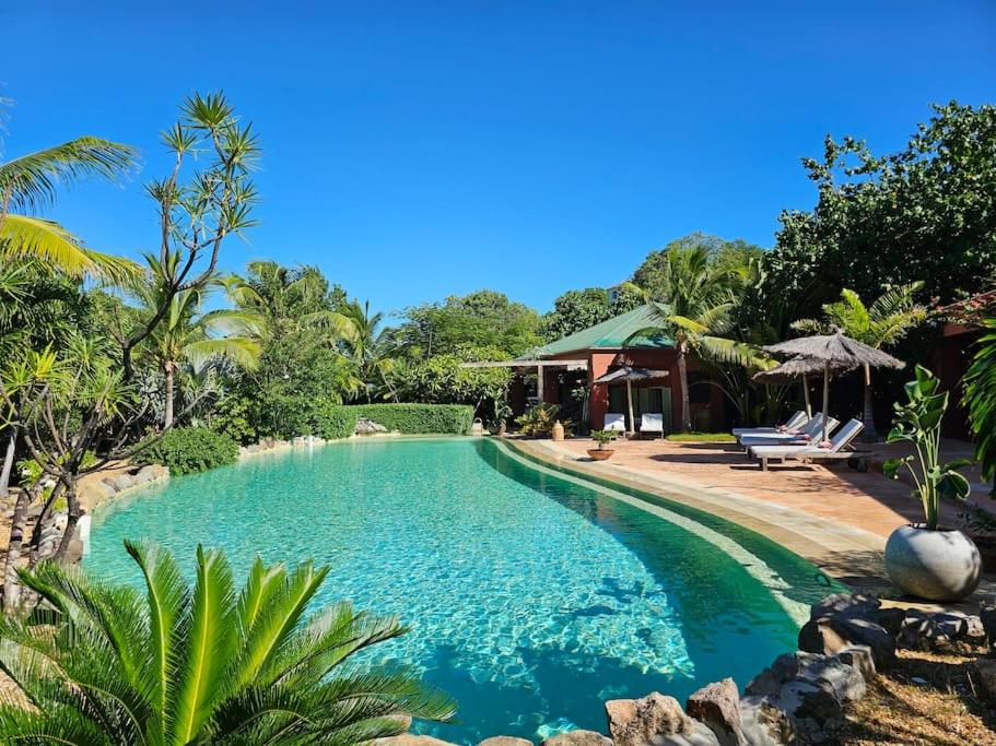 a swimming pool in a resort with two chairs at Villa African Queen - St Barth in Gustavia