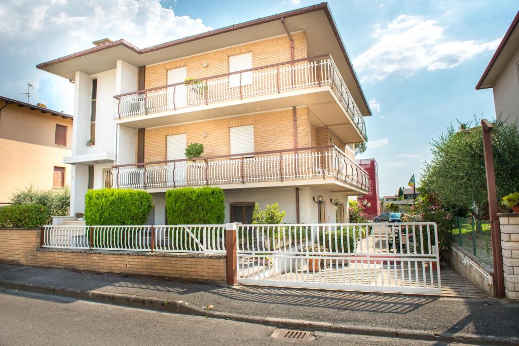 un edificio con una valla blanca delante de él en Hotel Santa Maria en Assisi