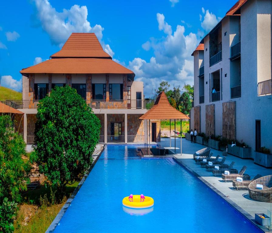 a swimming pool with a yellow boat in the middle at Sajjan Bagh Resort Kumbhalgarh in Kumbhalgarh