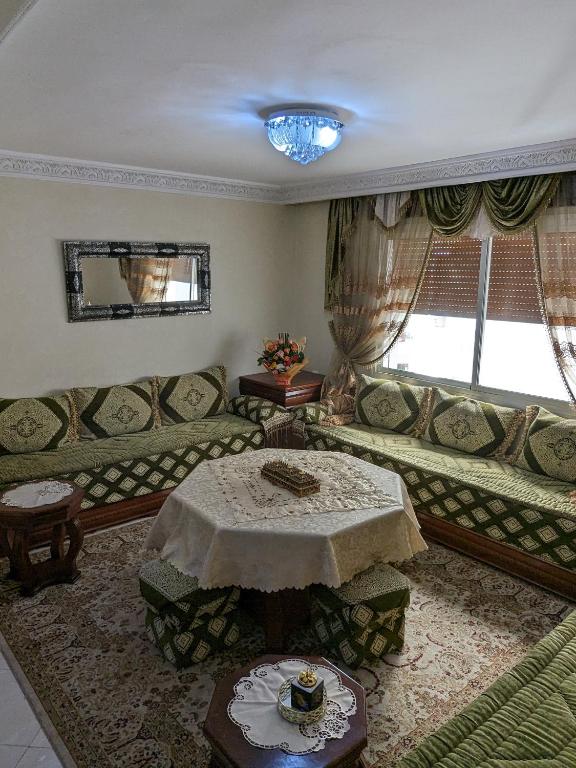 ein Wohnzimmer mit einem Sofa und einem Tisch in der Unterkunft Tangier Central Comforts: Your Moroccan Home with Cultural Proximity in Tangier