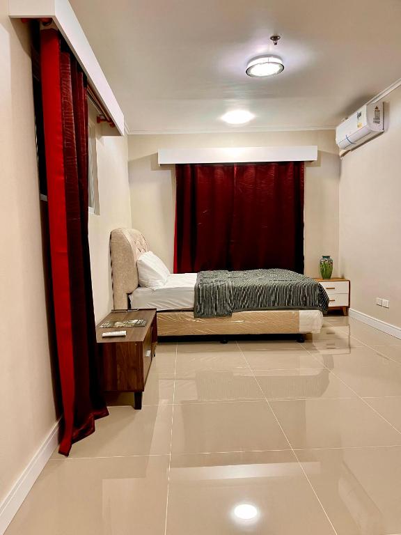 a bedroom with a bed and a red curtain at 1 bedroom condominium in Lapu2x in Lapu Lapu City