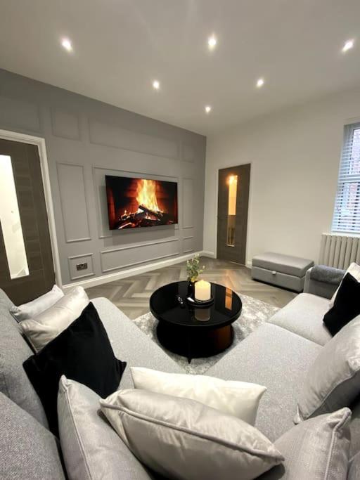 a living room with a couch and a fireplace at A home away from home in Manchester