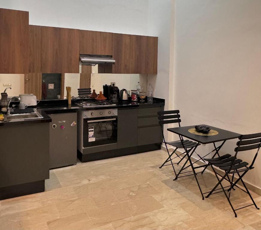 uma cozinha com mesa e cadeiras num quarto em Take a cosy rest Near the airport em Nouaceur